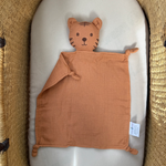 Orange tiger baby comfort blanket in a crib